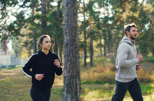 Man and woman jogging together in a park.