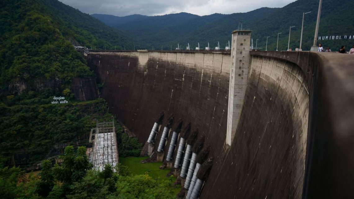 Bhumibol Dam in Ban Na, Tak, Thailand, surrounded by lush greenery and mountains.