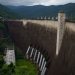 Bhumibol Dam in Ban Na, Tak, Thailand, surrounded by lush greenery and mountains.